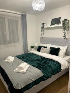 een slaapkamer met een groot bed en handdoeken bij Stockwood Apartment by Cliftonvalley Apartments in Bristol