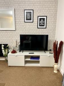 un centro de entretenimiento blanco con TV de pantalla plana en Stockwood Apartment by Cliftonvalley Apartments, en Bristol