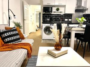 a living room with a couch and a washing machine at Stockwood Apartment by Cliftonvalley Apartments in Bristol