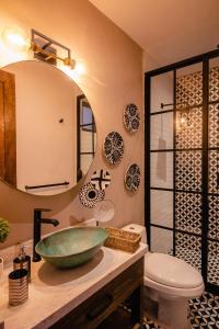 een badkamer met een wastafel en een spiegel bij Casamada Residences in Guanajuato