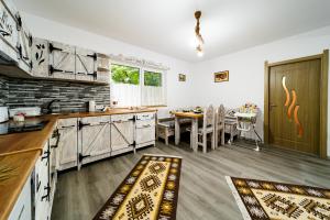 a kitchen with a table and a dining room at Kata Kulcsosház in Odorheiu Secuiesc