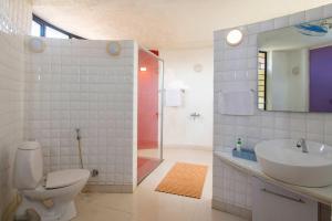 a bathroom with a toilet and a sink and a shower at StayVista's Villa Kornet - Mountain-view luxury with a swimming pool and a spacious lawn adorned with a gazebo in Panvel