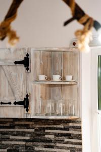 a glass cabinet with plates and cups on it at Kata Kulcsosház in Odorheiu Secuiesc