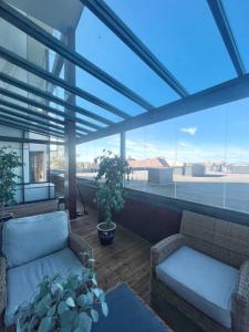 eine Terrasse mit 2 Stühlen und einem Sofa auf dem Balkon in der Unterkunft Kotimaailma - Premium 2 bedroom apartment with Terrace & Sauna in Vantaa