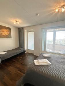 1 Schlafzimmer mit 2 Betten und einem großen Fenster in der Unterkunft Kotimaailma - Premium 2 bedroom apartment with Terrace & Sauna in Vantaa