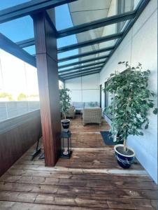 eine Veranda mit zwei Topfpflanzen auf einem Gebäude in der Unterkunft Kotimaailma - Premium 2 bedroom apartment with Terrace & Sauna in Vantaa