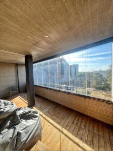 Schlafzimmer mit einem großen Fenster mit Stadtblick in der Unterkunft Kotimaailma - Premium 2 bedroom apartment with Terrace & Sauna in Vantaa