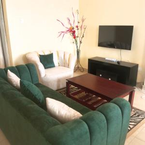 a living room with a green couch and a coffee table at Eva's haven in Kakamega