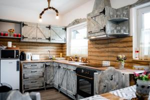 a kitchen with wooden cabinets and a white refrigerator at Kata Kulcsosház in Odorheiu Secuiesc