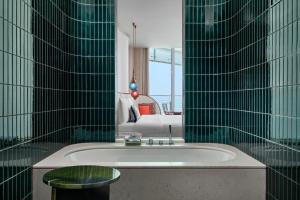 a bathroom with a tub and a couch in a room at W Dubai - Mina Seyahi, Adults Only in Dubai
