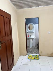 a bathroom with a sink and a mirror at Yogi Home Stay Near Freetown Airport in Freetown