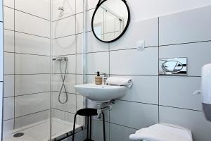 Un baño blanco con lavabo y espejo. en Apartamenty Folk Deluxe, en Lublin 42 fotos más