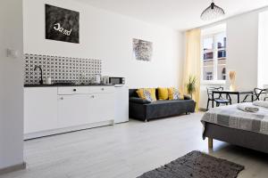 a white apartment with a kitchen and a living room at Folk Deluxe in Lublin