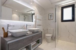 a bathroom with two sinks and a toilet and a shower at Résidence Pierre & Vacances Premium Domaine du Golfe du Lion in Saint-Cyprien