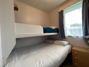 a small bedroom with a bunk bed and a window at Kiwi Classic in Matapouri