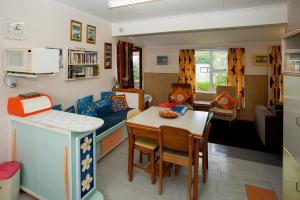 a kitchen and living room with a table and a dining room at Kiwi Classic in Matapouri