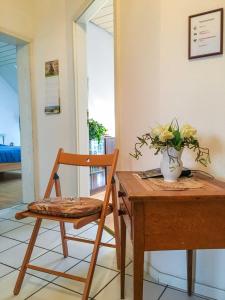 a wooden table with a chair and a vase with flowers at City-Dachapartment Mainz in Mainz +6 photos