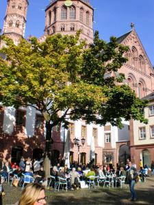 eine Gruppe von Personen, die vor einem Gebäude auf Stühlen sitzen in der Unterkunft City-Dachapartment Mainz in Mainz