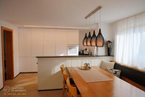 una cucina con tavolo in legno e una cucina con bancone di RM Apartment for Moments a Dornbirn