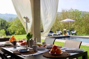 una mesa con comida junto a una piscina en Villa Grassi with pool Nizza Monferrato, en Calamandrana