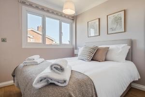 a bedroom with a bed with towels on it at Stunning and Modern House - Perfect for Families in Bedford