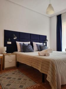 a bedroom with a large bed with a blue headboard at King`s Apartaments in San Javier
