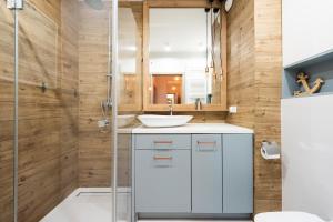 a bathroom with a sink and a shower at City Center SPA Apartments Jaglana 6E,F in Gdańsk