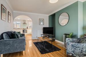 uma sala de estar com dois sofás e uma televisão em Stunning and Modern House - Perfect for Families em Bedford