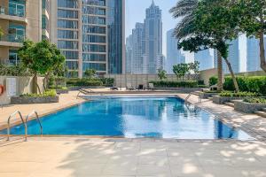 a swimming pool with a city skyline in the background at Frank Porter - The Lofts East in Dubai