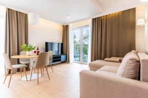 a living room with a couch and a table at Marina Nautica - nowy, parking podziemny, winda, Netflix i Max, TV55" in Iława