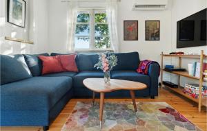 Beautiful Home In Holbk With Kitchen في هولباك: أريكة زرقاء مع طاولة في غرفة المعيشة