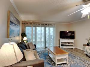 ein Wohnzimmer mit einem Sofa und einem TV in der Unterkunft Emerald Isle #709 in Fort Walton Beach
