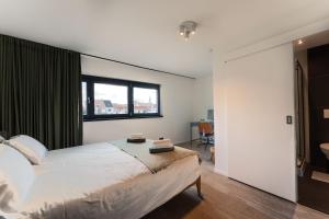 sypialnia z dużym łóżkiem i oknem w obiekcie Cosy & Spacious House in Center w mieście Kortrijk