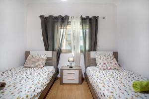 1 dormitorio con 2 camas individuales y ventana en A O - Azul Aprumado, en Peniche