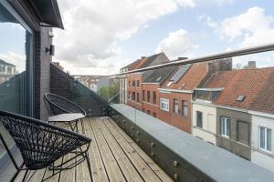 a balcony with two chairs and a view of buildings at Cosy & Spacious House in Center in Kortrijk