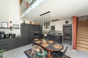 a kitchen with a wooden table and black cabinets at Cosy & Spacious House in Center in Kortrijk