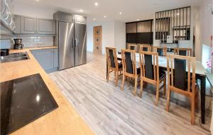 a kitchen with a table and chairs and a refrigerator at 2 Bedroom Amazing Apartment In Bstad in Båstad
