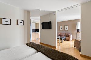 uma sala de estar com uma cama, um sofá e uma televisão em Best Western Solna Business Park em Solna