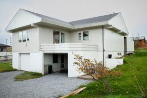 a white house with a garage at Apartment in Sørvágur in Sørvágur