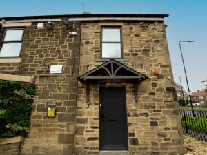an old brick house with a black door at Spacious Well Equipped Flat - Pass the Keys in Gosforth