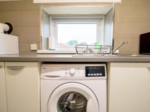 a kitchen with a washing machine and a sink at Pass the Keys Spacious Well Equipped Flat in Gosforth