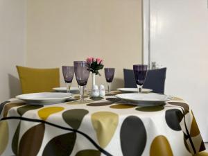 a table with plates and wine glasses on it at Spacious Well Equipped Flat - Pass the Keys in Gosforth