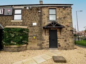 a brick house with a black door on it at Pass the Keys Spacious Well Equipped Flat in Gosforth