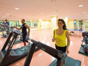 un homme et une femme marchant sur un tapis roulant dans une salle de sport dans l'établissement Morada Resort Kühlungsborn, à Kühlungsborn