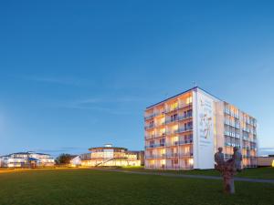 due persone in piedi di fronte a un edificio di Morada Resort Kühlungsborn a Kühlungsborn