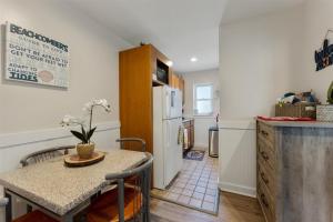 a kitchen with a table and a white refrigerator at 415 E Atlanta Ave, Unit 107 in Wildwood Crest