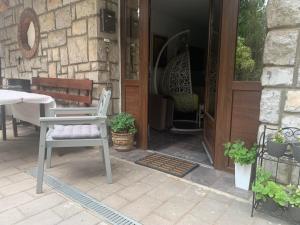 a porch with a table and a bench and a door at Vila Lucic Zlatibor in Zlatibor