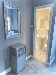 uma casa de banho com um espelho, um lavatório e um WC. em The Cresswell Inn em Skegness