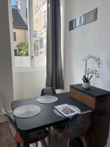 una mesa negra y sillas en una habitación con ventana en Le Terminus, en Aix-les-Bains