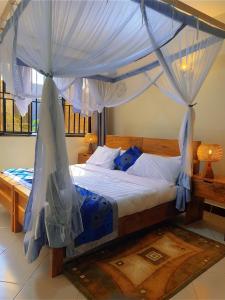 a bedroom with a bed with a canopy at Airportlinkguesthouse2 in Entebbe